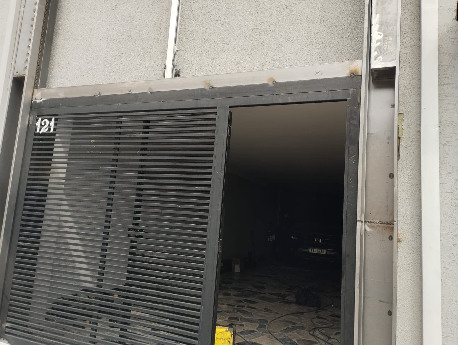 Portao de garagem instalado em fachada residencial